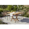 Deze sfeervolle setting illustreert een intiem buitenverblijf, ideaal voor een zomers ontbijt of een ontspannen middag in de tuin. De combinatie van warm teakhout en tactiel vlechtwerk creëert een tijdloze, natuurlijke esthetiek die naadloos aansluit bij 