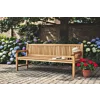 Klassieke tuinbank van massief teakhout met ergonomische rugleuning in een groene tuin met hortensia's.